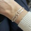 bracelet double trombone argent porte | 26 Passage, Créatrice de bijoux à Paris Silver geometric bracelet with connected rectangular links on a wrist, close-up view.