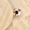 Bague twist vermeil grenat collection femme | 26 Passage, Créatrice de bijoux à Paris Rose-gold colored ring with a chunky, squared band and a faceted deep red gemstone set in a low bezel, resting on a light wooden surface.