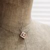 pendentif mikado vermeil zircon naturel rond sur presentoir | 26 Passage, Créatrice de bijoux à Paris Close-up of a burlap mannequin bust wearing a geometric square pendant necklace with a diamond-shaped cutout and gem centerpiece.