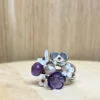 bague prairie argent amethyste nacre rose perle | 26 Passage, Créatrice de bijoux à Paris Flower-themed multi-band ring with purple and white petal charms on a wooden surface, jewelry detail jewelry.