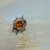 bague double branche melange vermeil argent noir citrine madere vue dessus | 26 Passage, Créatrice de bijoux à Paris Silver-toned ring with a tangled branch setting and an oval orange gem at center.