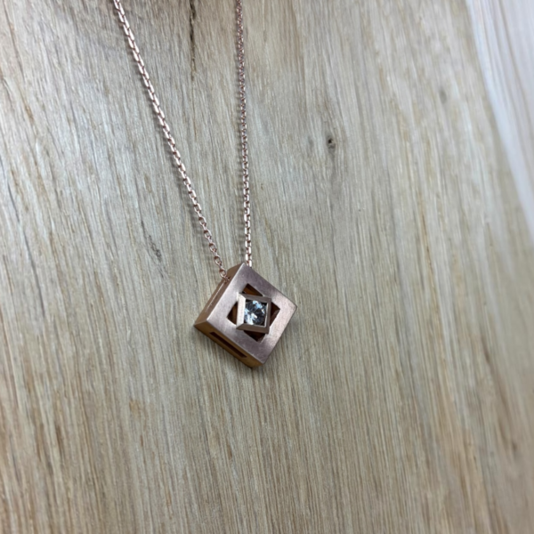 collier mikado vermeil zircon sur chaine | 26 Passage, Créatrice de bijoux à Paris Rose gold geometric pendant necklace with square frame and central diamond-like stone on a delicate chain.