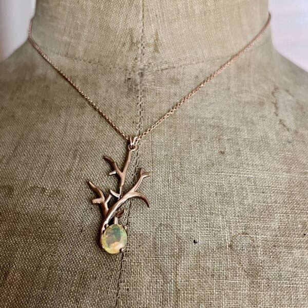 collier branche en vermeil rose opale d ethiopie | 26 Passage, Créatrice de bijoux à Paris Rose-gold necklace with a branching antler-like pendant and an oval opal gemstone displayed on a fabric dress form.